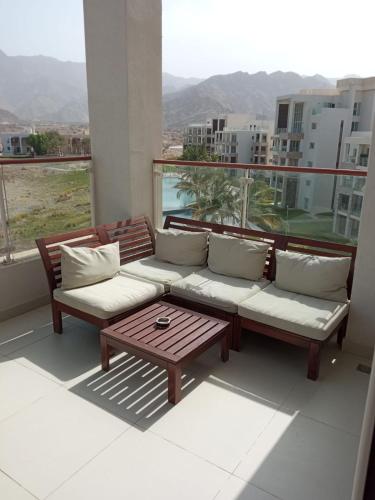 a couch and a coffee table on a balcony at Sifah Inn in As Sīfah