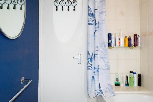 a bathroom with a blue shower curtain and a tub at Angel Newbery in London