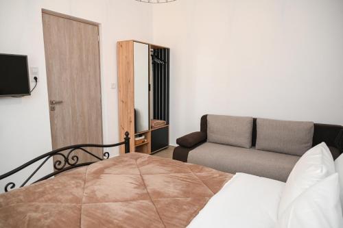 a bedroom with a bed and a couch at Gemilos Nest in Komia