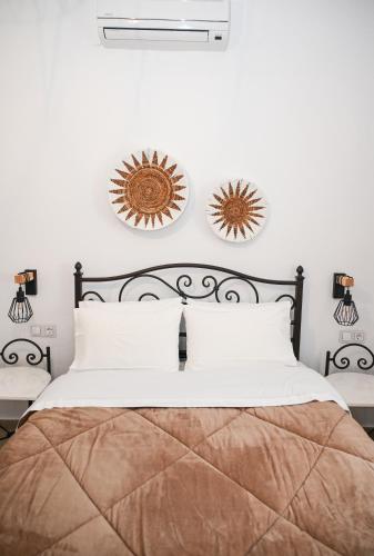 a bedroom with a bed and two mirrors on the wall at Gemilos Nest in Komia