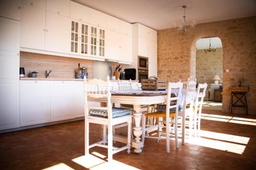 eine Küche mit einem Holztisch und Stühlen in der Unterkunft Domaine de la Briouse in Sanxay