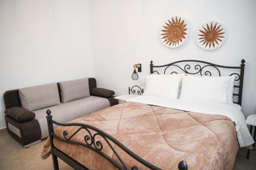 a bedroom with a bed and a couch at Gemilos Nest in Komia