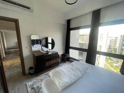 een slaapkamer met een bed en een grote spiegel bij Madinaty Apartment in Madinaty