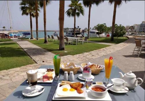 a table with breakfast food and drinks on a beach at Sifah Inn in As Sīfah