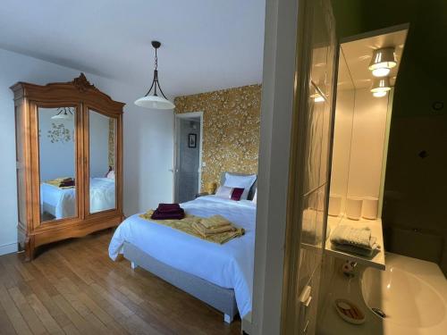 une chambre avec un lit et un grand miroir dans l'établissement Un brin de bonheur, à Troyes
