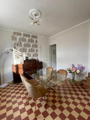 une salle à manger avec une table et des chaises en verre dans l'établissement Un brin de bonheur, à Troyes