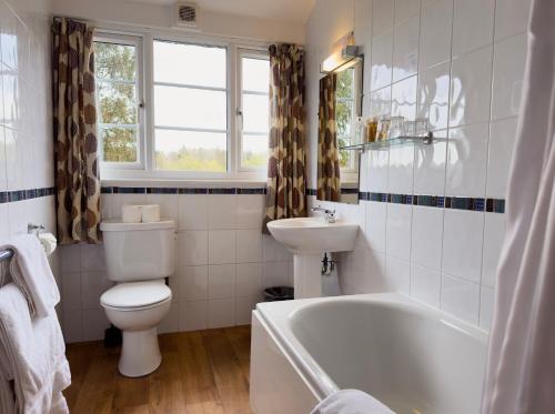 La salle de bains est pourvue de toilettes, d'une baignoire et d'un lavabo. dans l'établissement Skelwith Bridge Hotel, à Ambleside