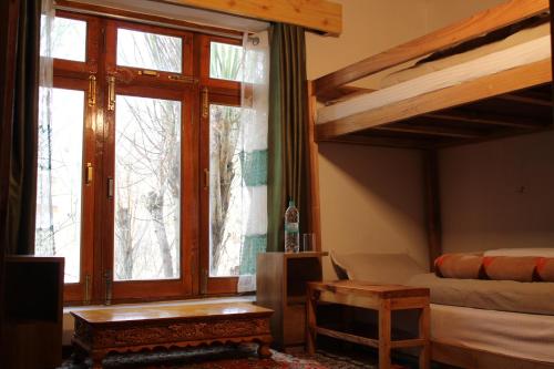 sala de estar con cama elevada y sofá en Karma Lodge - "A Boutique stay in Leh" en Leh