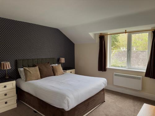 فندق Skelwith Bridge في آمبيلسايد: غرفة نوم بسرير كبير ونافذة