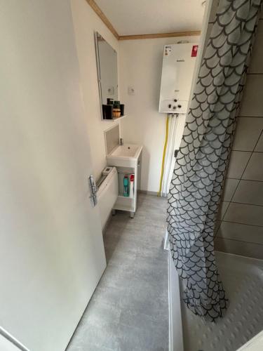 a bathroom with a sink and a shower curtain at Mobil-home camping 4 étoiles N35 in Fourmies