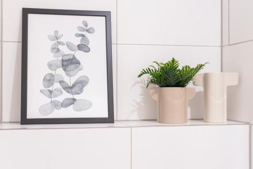a picture frame sitting on a shelf with a plant at UNiQE Apartments Oldtown - citycenter in Dresden
