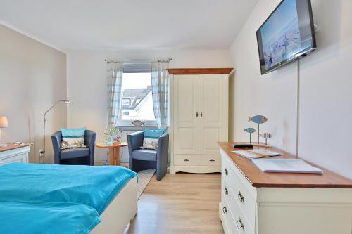 a bedroom with a bed and a desk with a tv at Ferienhaus Brandt Ferienhaus Brandt Appartement 2 Plattschnacker in Haffkrug