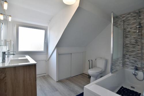 une salle de bain blanche avec un lavabo et des toilettes dans l'établissement Douceur Malouine - Maison familiale avec jardin, à Saint-Malo