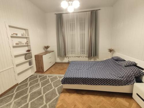 duża sypialnia z łóżkiem i oknem w obiekcie Kamienica Mikołajki w mieście Mikołajki