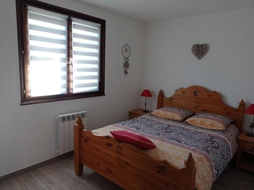 a bedroom with a bed with a red pillow on it at Charmant 3 pièces classé 3* avec belle vue lac in Neuvecelle