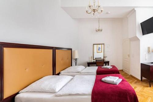 1 Schlafzimmer mit 2 Betten mit roter Bettwäsche und einem Kronleuchter in der Unterkunft Studio an der Therme in Baden-Baden