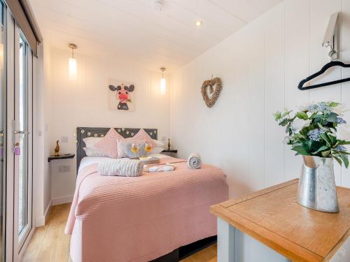 a bedroom with a bed with a pink blanket at Galloway Views - Uk46816 in Wigtown