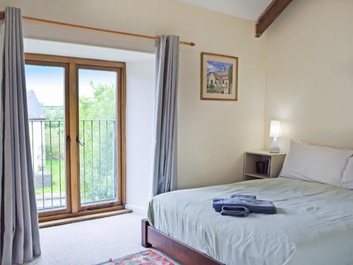 a bedroom with a bed and a large window at Lower Barn in Pencader