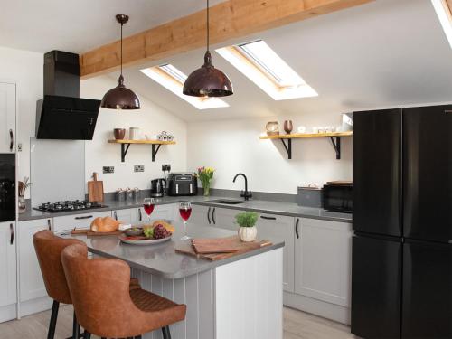 a kitchen with a black refrigerator and a table at Briar Cottage in Great Eccleston