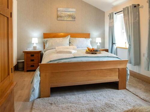 a bedroom with a bed with a tray of fruit on it at Briar Cottage in Great Eccleston