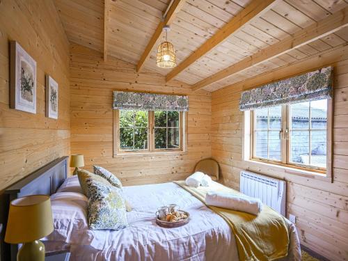 ein Schlafzimmer mit einem Bett in einer Holzhütte in der Unterkunft Stable Lodge At Greenacre in Bromyard