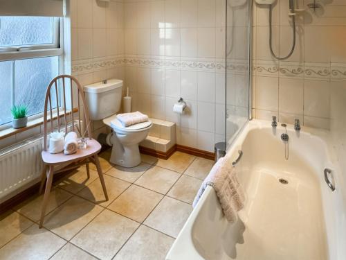 a bathroom with a tub and a toilet at Elens Place in Tywyn