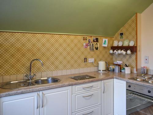 a kitchen with a sink and a counter top at Green Shutters in Harmston