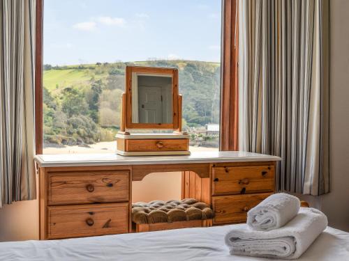 a bedroom with a dresser with a mirror and a window at Marine Mews 3 in Salcombe