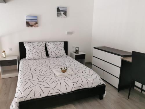 a bedroom with a black and white bed and a dresser at Gite De La Gâche in Saint-Christoly-de-Blaye