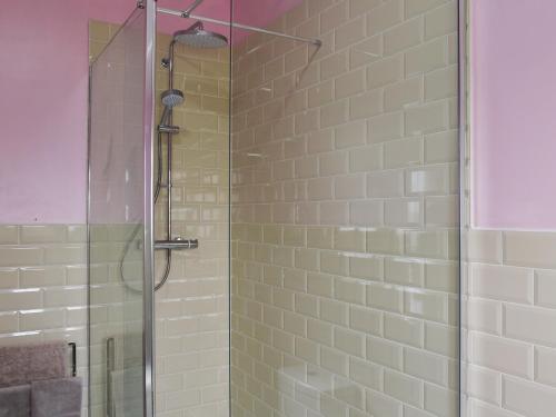 um chuveiro com uma porta de vidro na casa de banho em Stable Cottage - Uk45134 em Barnby