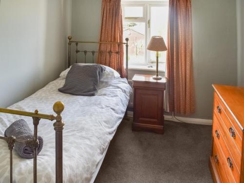 sypialnia z łóżkiem, komodą i oknem w obiekcie Heath View w mieście Saxmundham
