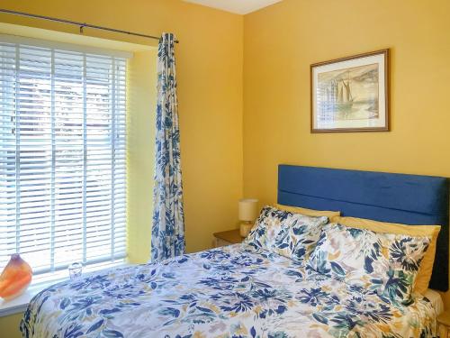 a bedroom with a blue bed and a window at The Hideaway in Crieff