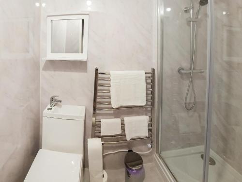 a bathroom with a toilet and a shower with towels at Queen House in Belper