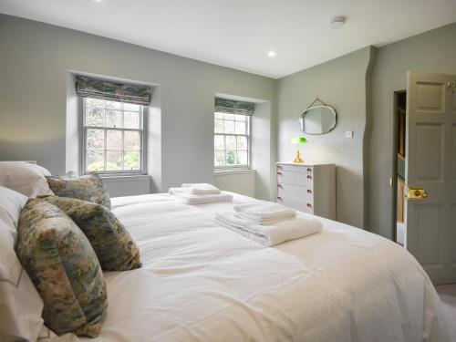 uma grande cama branca num quarto com janelas em Moncrieff House em Falkland