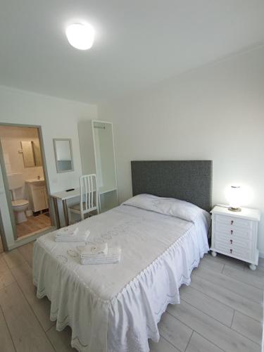 1 dormitorio con 1 cama grande con manta blanca en Casa Talika, en Fátima