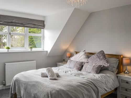 a bedroom with a bed and two windows at Garden Cottage in Nafferton