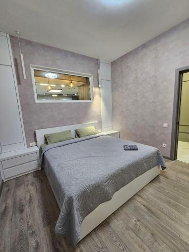 a bedroom with a large bed and a mirror at Centre Apartment in Gyumri