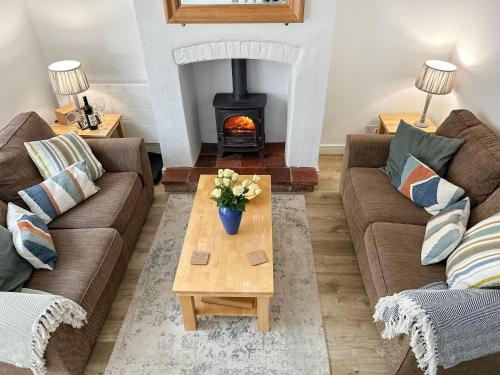 a living room with two couches and a wood stove at Rectory Cottage - Uk46995 in Overstrand