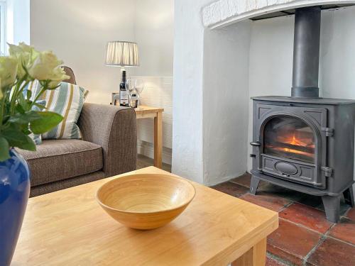 a living room with a wood stove on a table at Rectory Cottage - Uk46995 in Overstrand