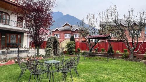 a patio with a table and chairs in a yard at Abshar Heritage Villa in Srinagar