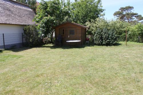 a small wooden shed in a yard next to a house at "Fewo-Ulla- 1" Ferienwohnung im EG in Dierhagen