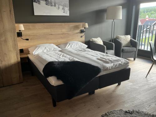 a large bed in a room with a chair and a bed sidx sidx at Trysil Alpine Lodge in Trysil