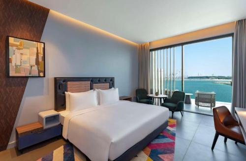 ドバイにあるHyatt Centric Jumeirah - King Room Sea View - UAEのベッドと大きな窓が備わるホテルルームです。