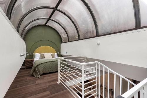 1 dormitorio con 1 cama y una escalera en una habitación en Modern Mid Century Getaway. Luxury by Hollyhock en Louisville