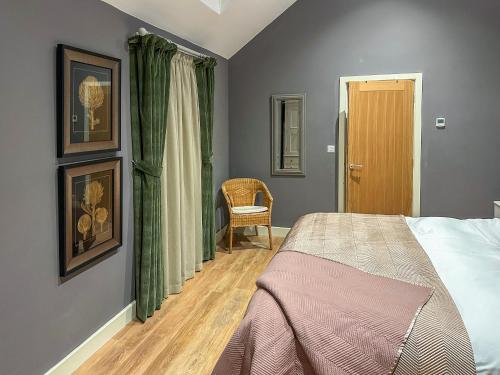 een slaapkamer met een bed en een stoel bij Ling At Holly House - Uk44468 in Newton