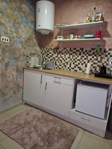 a kitchen with white cabinets and a counter top at Pravo mesto in Bajina Bašta