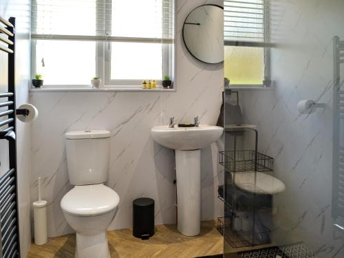 uma casa de banho branca com um WC e um lavatório em Canda em Holywood