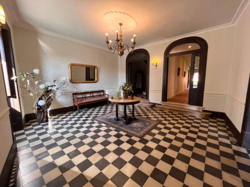 a lobby with a table and a chandelier at Palacete da Real Companhia do Cacau - Royal Cocoa Palace in Montemor-o-Novo