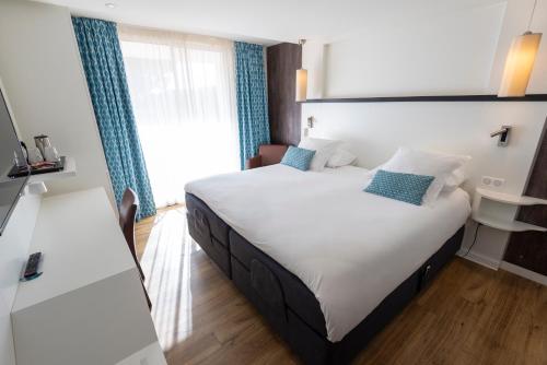a hotel room with two beds and a window at Côté Thalasso Hôtel & Spa Marin in Banyuls-sur-Mer