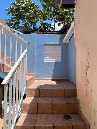 una escalera que conduce a un edificio azul con ventana en Santoni’s Luxury Rentals, en Cabo Rojo